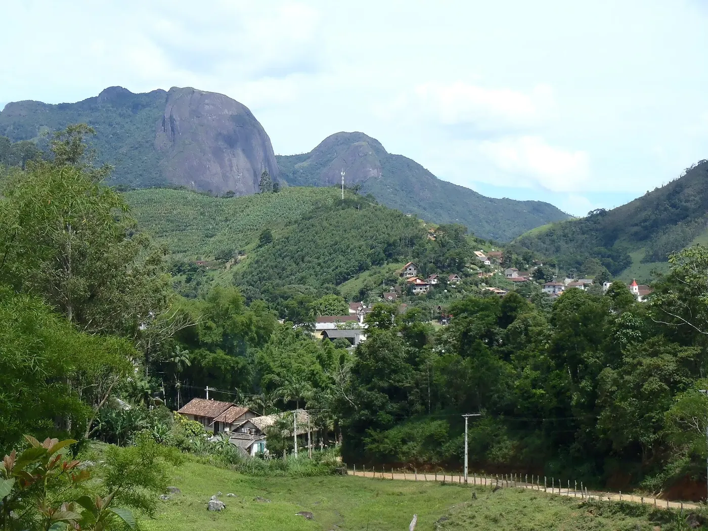 Casas espalhadas pela encosta de Lumiar diante de picos de granito
