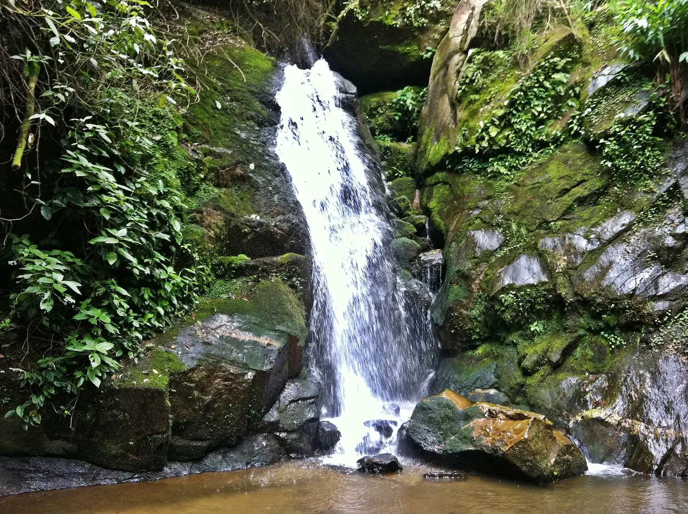 Cachoeira São José caindo entre rochas e mata em Boa Esperança, Lumiar